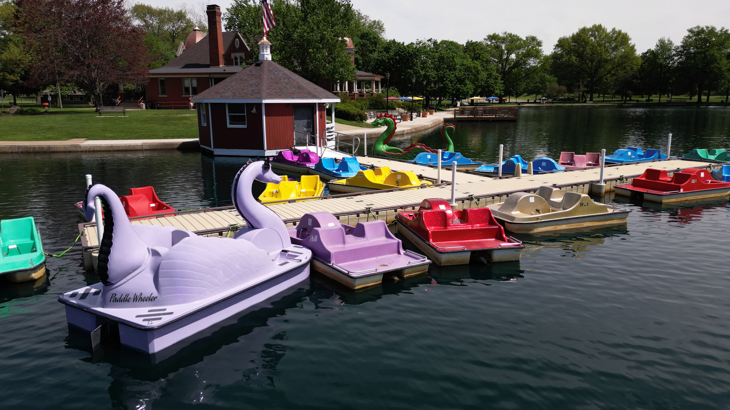 empty paddle boats on the boat dock near the boathouse and pavilion on the lagoon